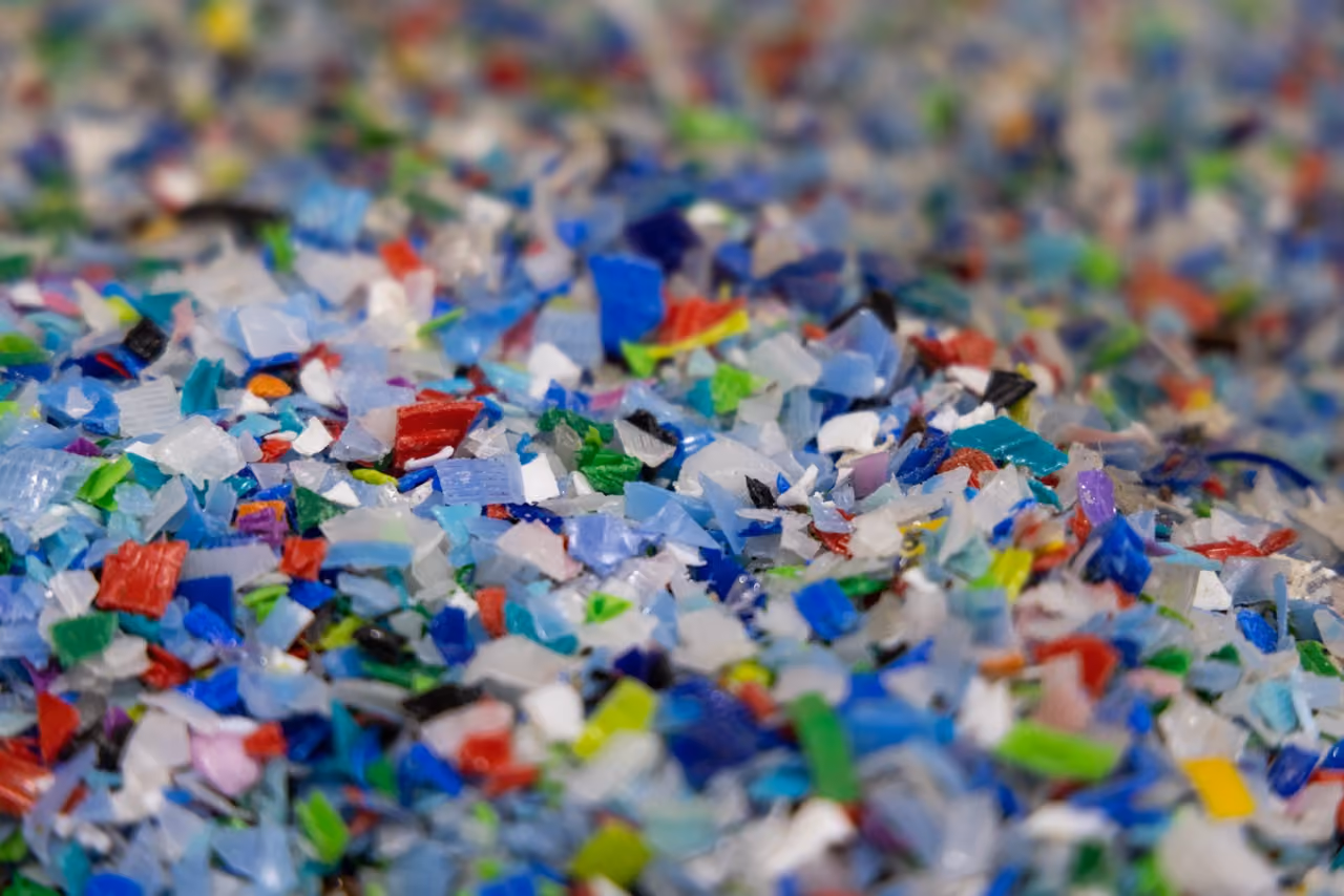 Close-up of colorful plastic fragments in various shapes and sizes, likely for recycling or reuse.
