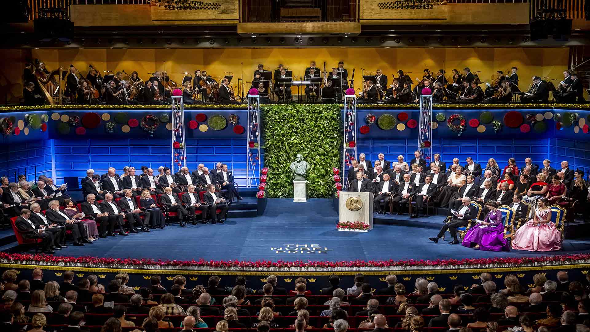 Nobel Prize award ceremony on stage before a full auditorium.
