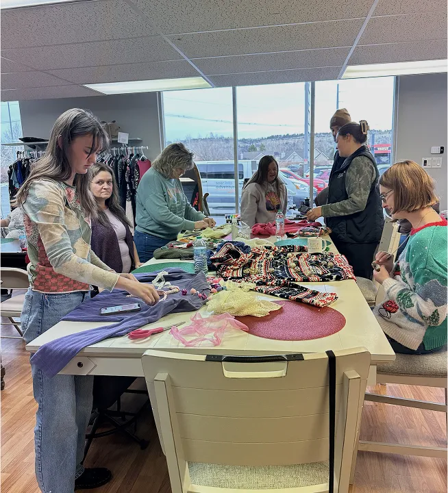 Group of women decorating holiday sweaters together during a Switch Society community workshop.