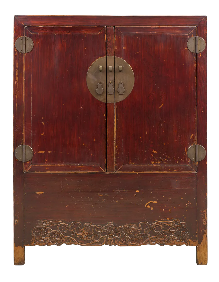 Niedriger, rot lackierter Schrank mit zwei Türen, großen runden Messingbeschlägen und seitlichen Scharnierplatten; unten mit geschnitzter Zierleiste