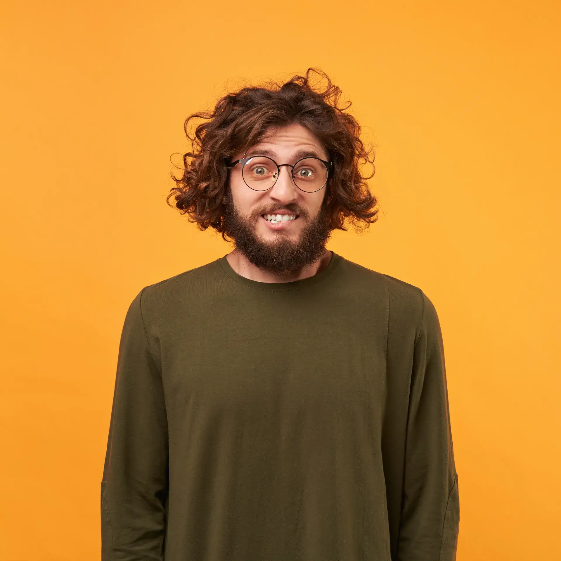 a man with a beard and glasses standing in front of an orange background