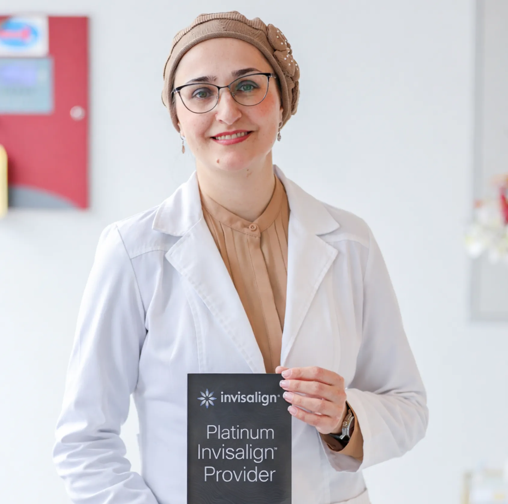 Dr. Dayanayeva holding Invisalign Platinum Plaque