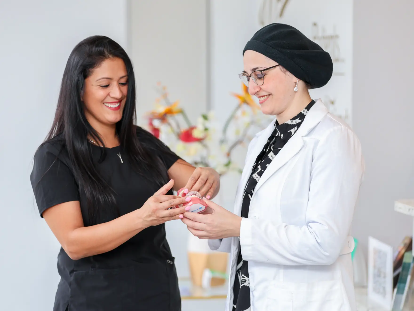 Team membe and Dr. Mariya Dayanayeva holding a denture
