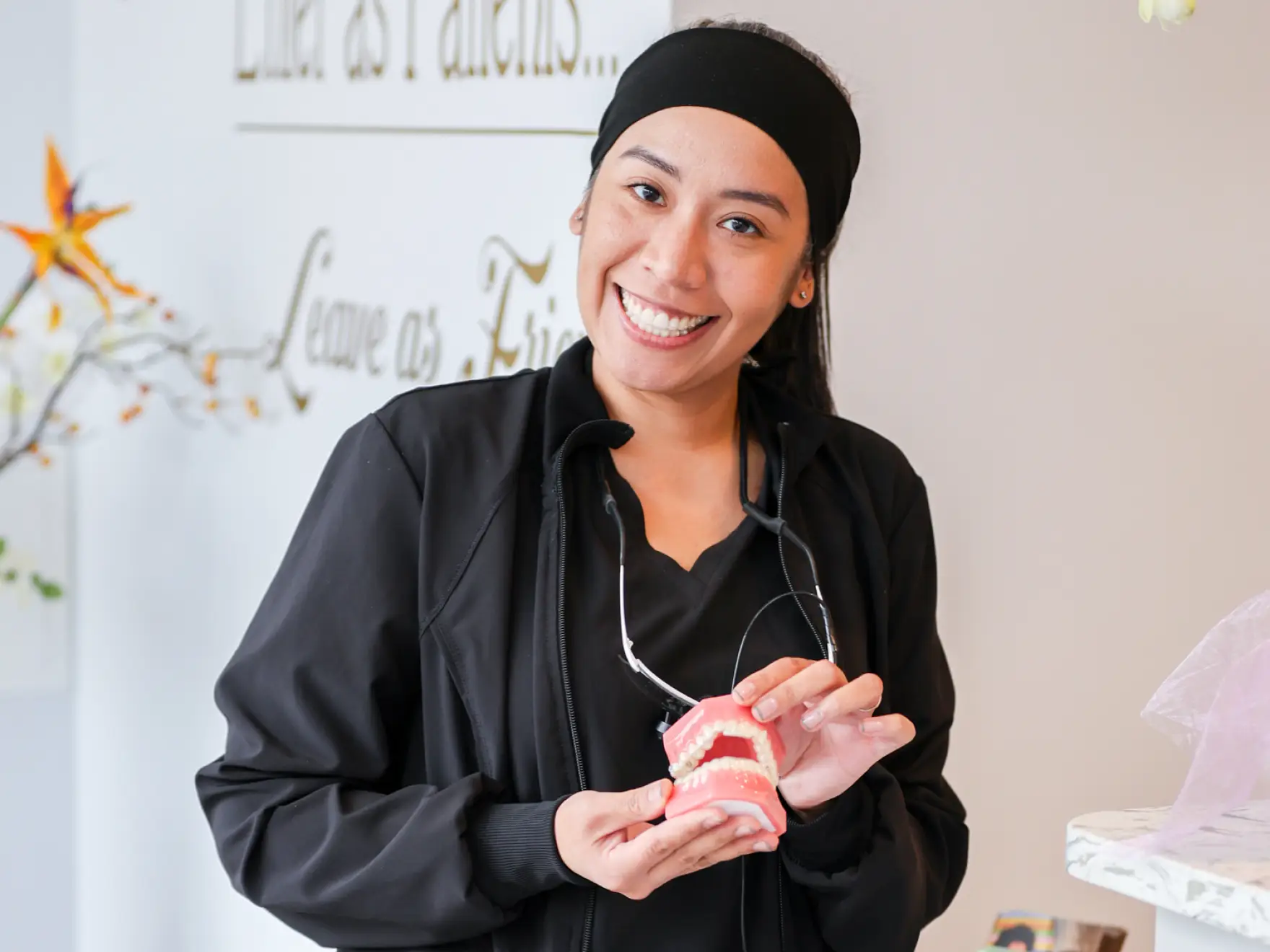 The Dental Suite team member holding a denture