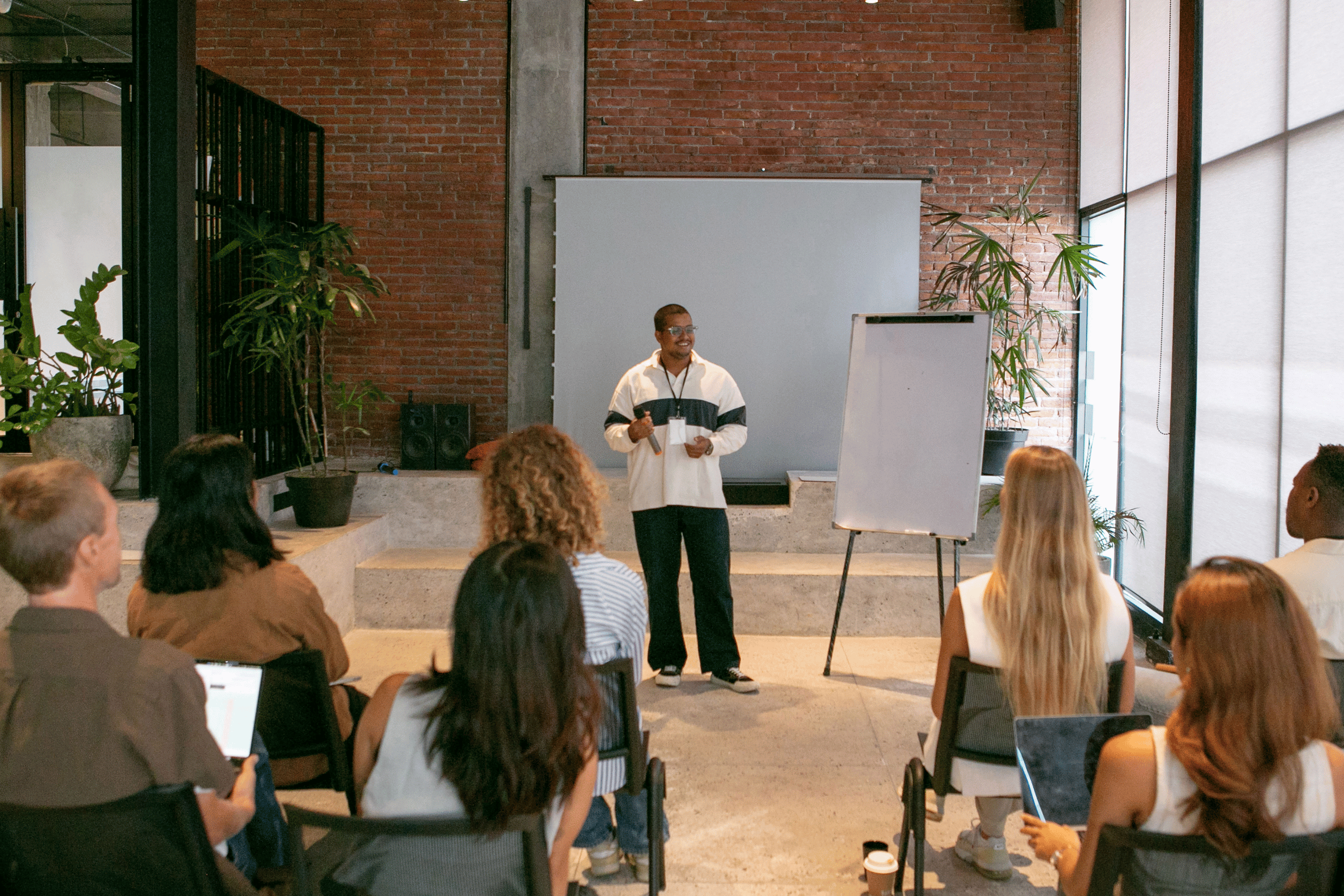 Facilitator leading an interactive adult learning workshop where participants collaborate and reflect in small groups.