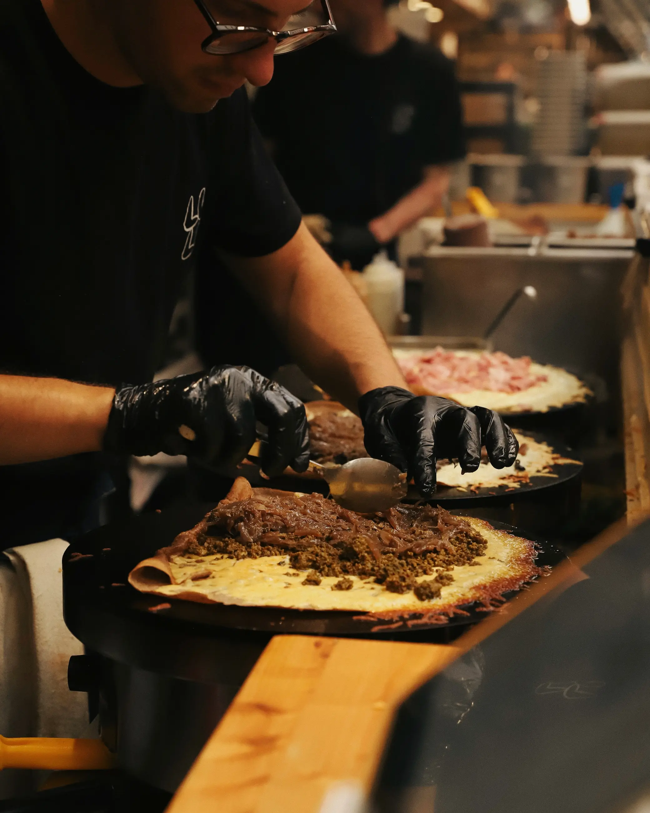 Fresh savoury crêpe being prepared at a food stall in Marché des Enfants Rouges, the oldest covered food market in Paris.