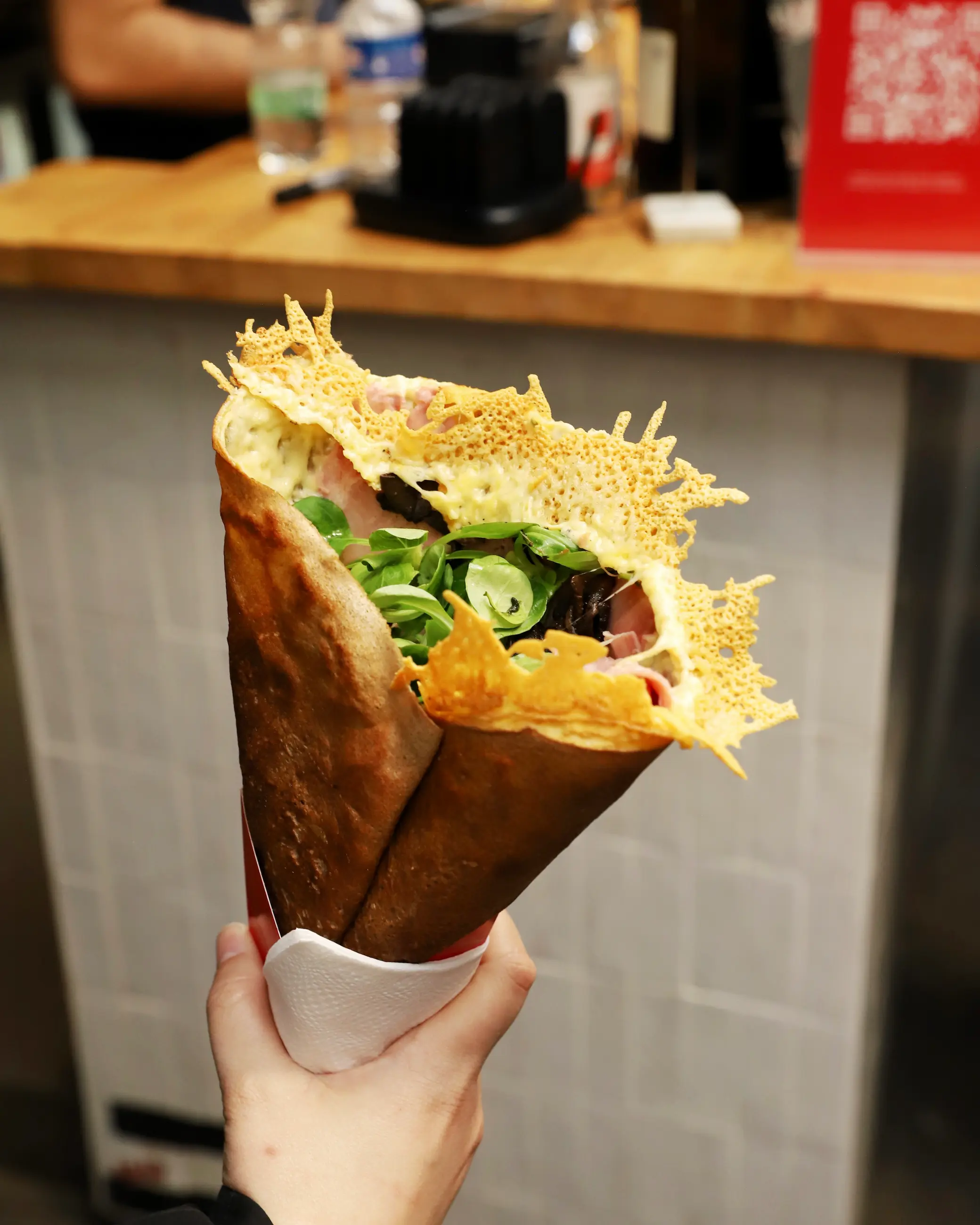 Fresh savoury crêpe with cheese, ham and salad from Marché des Enfants Rouges food market in Paris.