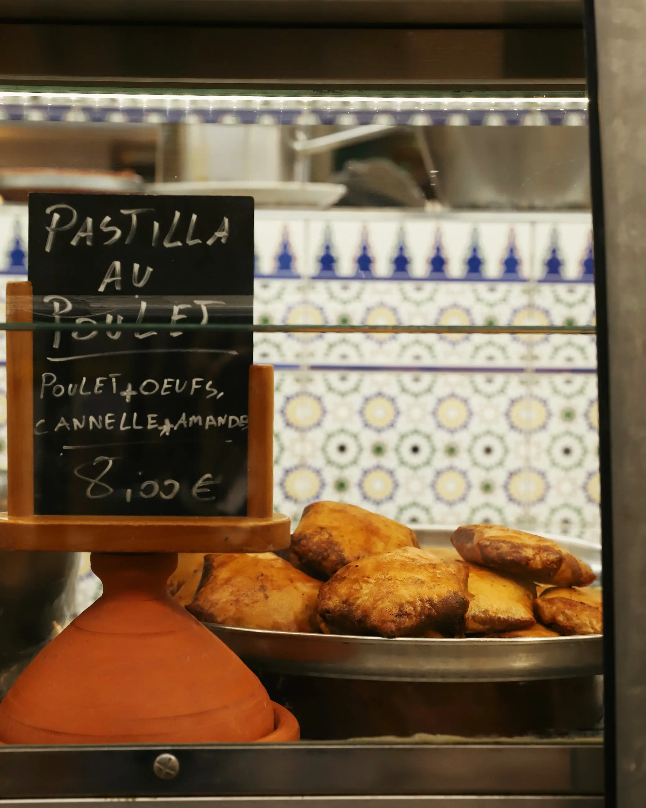 Chicken pastilla pastries on display at a food stall in Marché des Enfants Rouges food market in Paris.
