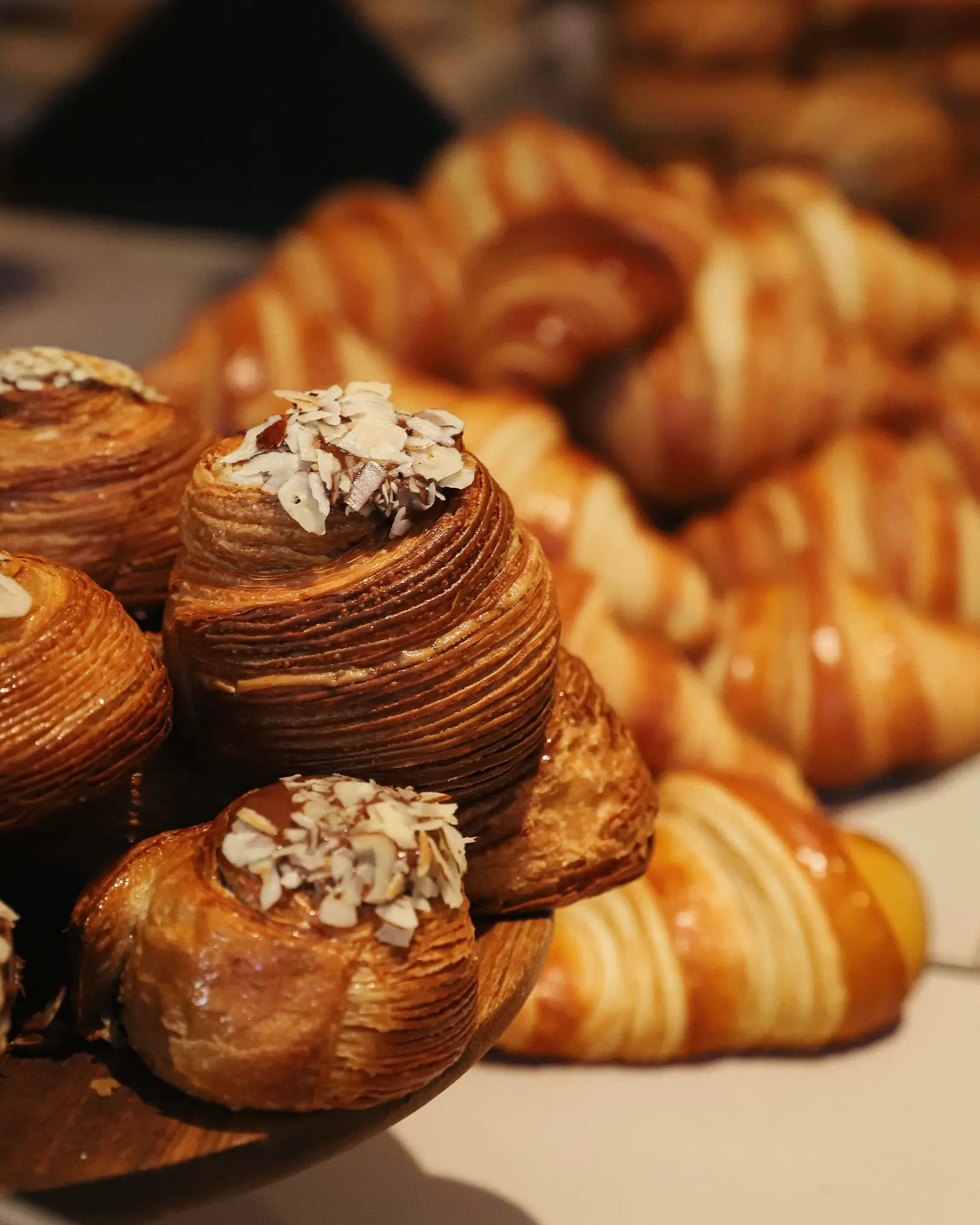 Fresh croissants and laminated pastries displayed in a Paris bakery.