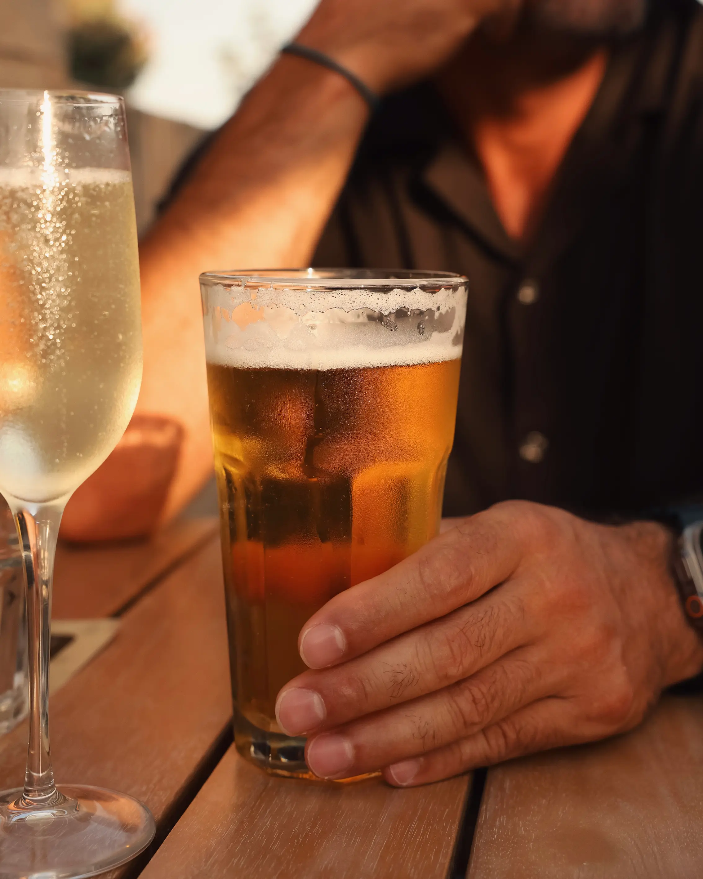 Ice-cold Cisk beer and sparkling wine on the rooftop terrace at O Sole in warm evening light above Va