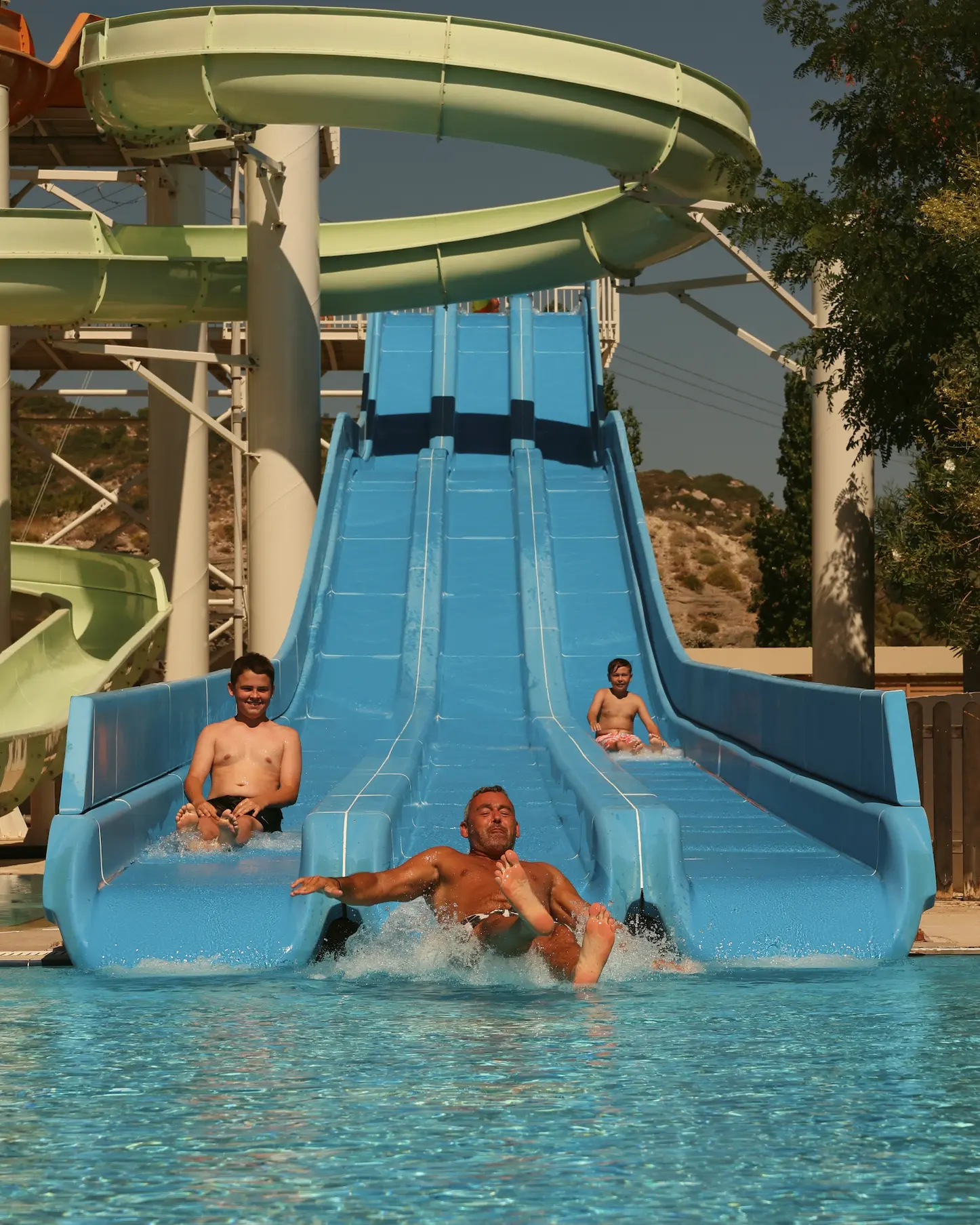Family enjoying the waterpark slides at Amada Colossos Resort in Rhodes, Greece.