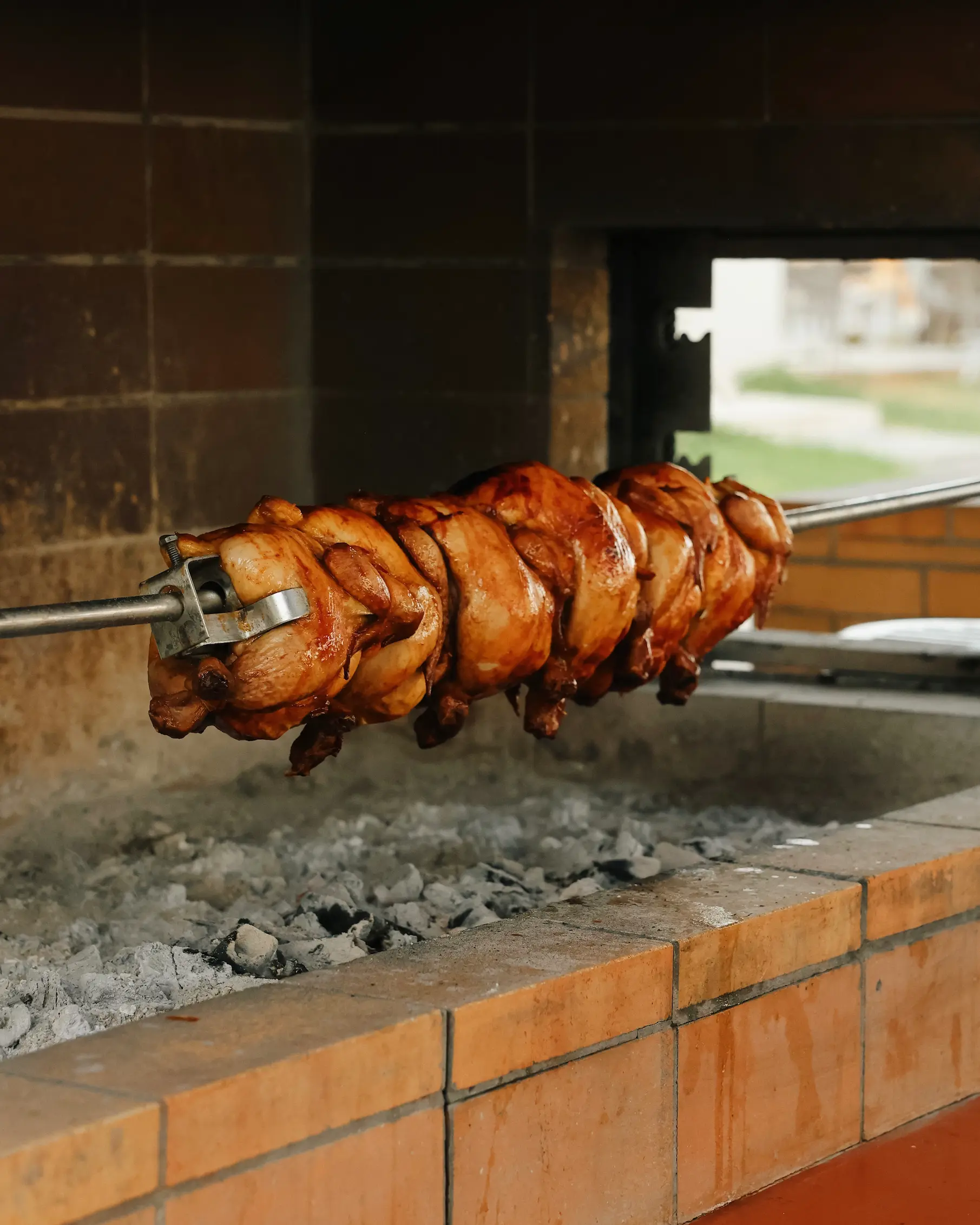 Rotisserie chicken cooking over hot coals at Enalia Seaside Restaurant, Amada Colossos Resort in Rhodes.