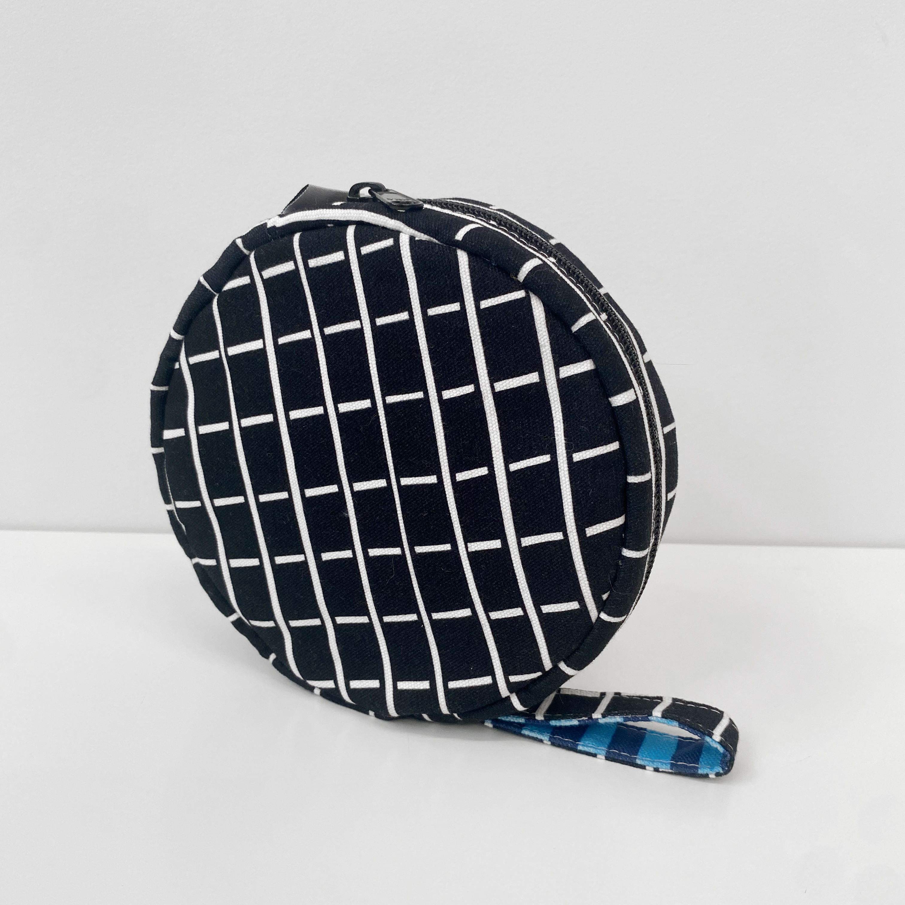 A square pillow with light blue and white stripes.