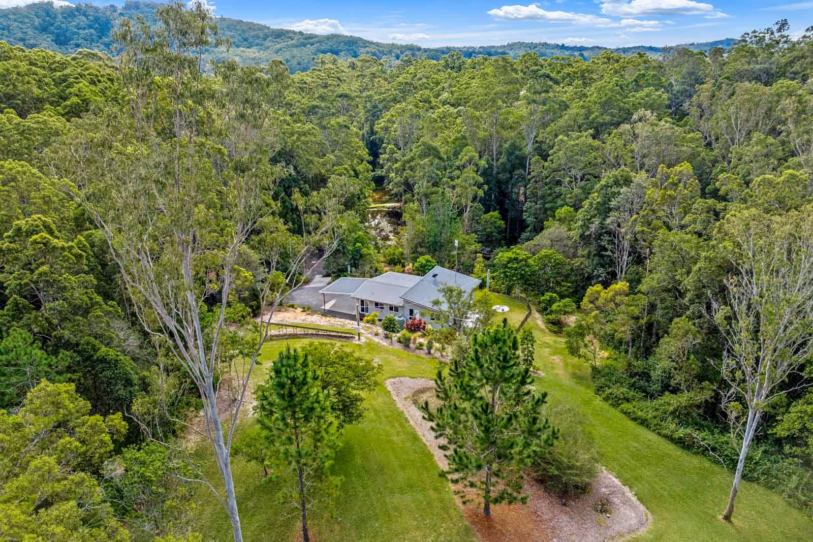 Welcome to this exceptionally private and peaceful acreage residence, offering everything you could wish for in a tranquil retreat. Spanning across 19 acres in a secluded valley, this property features a near-new 3-bedroom, 2-bathroom home, a charming 1-bedroom, 1-bathroom cabin currently listed on Airbnb, multiple sheds, a fenced horse paddock, dams for recreational activities and irrigation, picnic areas, cleared grassed spaces, and well-maintained walking trails throughout.