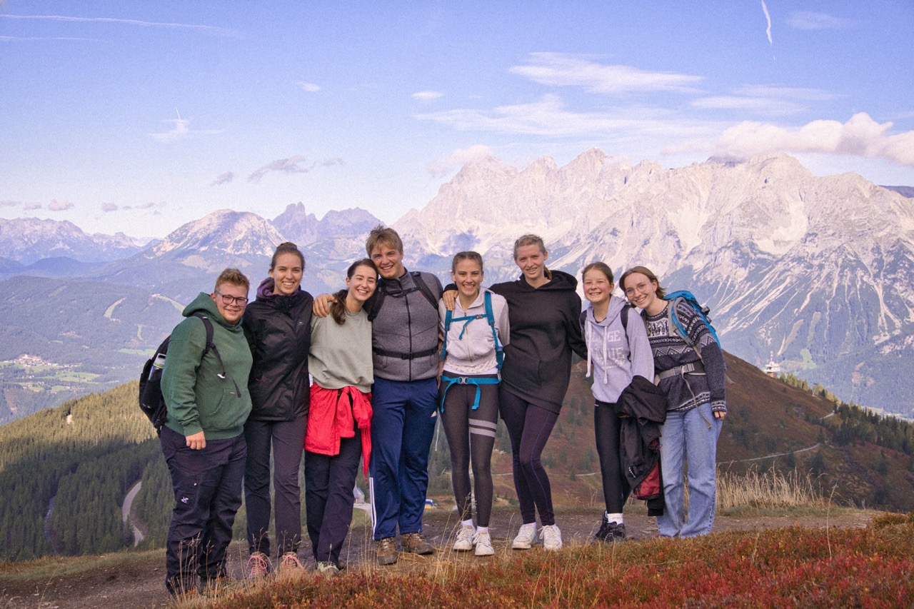 Eine Gruppe junge Erwachsener von GrowDeep steht in den Bergen und mach ein Gruppenfoto