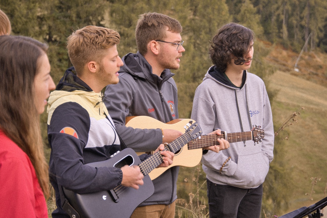 GrowDeep Jugendliche stehen in der Natur und machen gemeinsam Lobpreis. Zwei Gitarrenspieler singen.