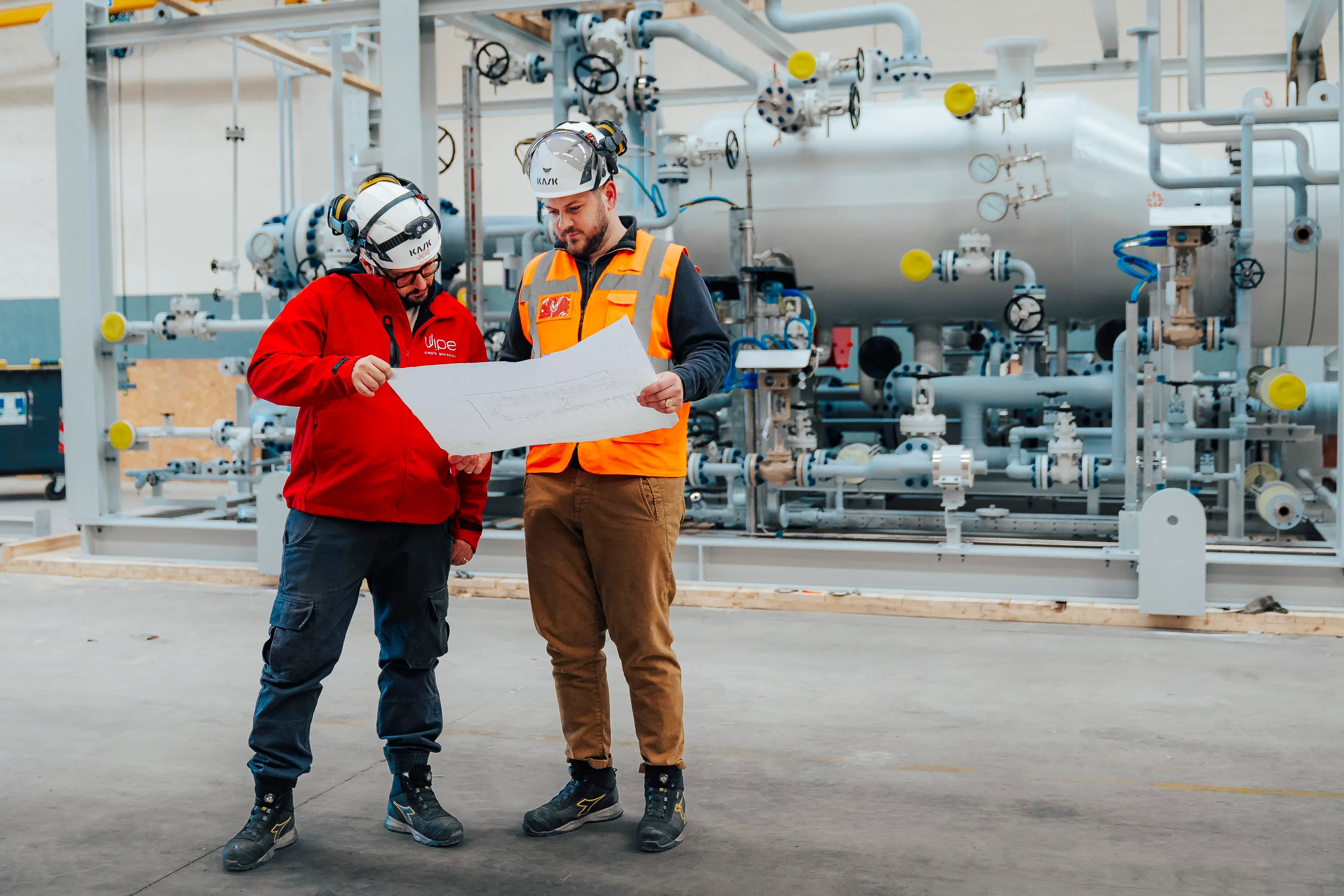 Two oil and gas plant supervisors watching a drawing