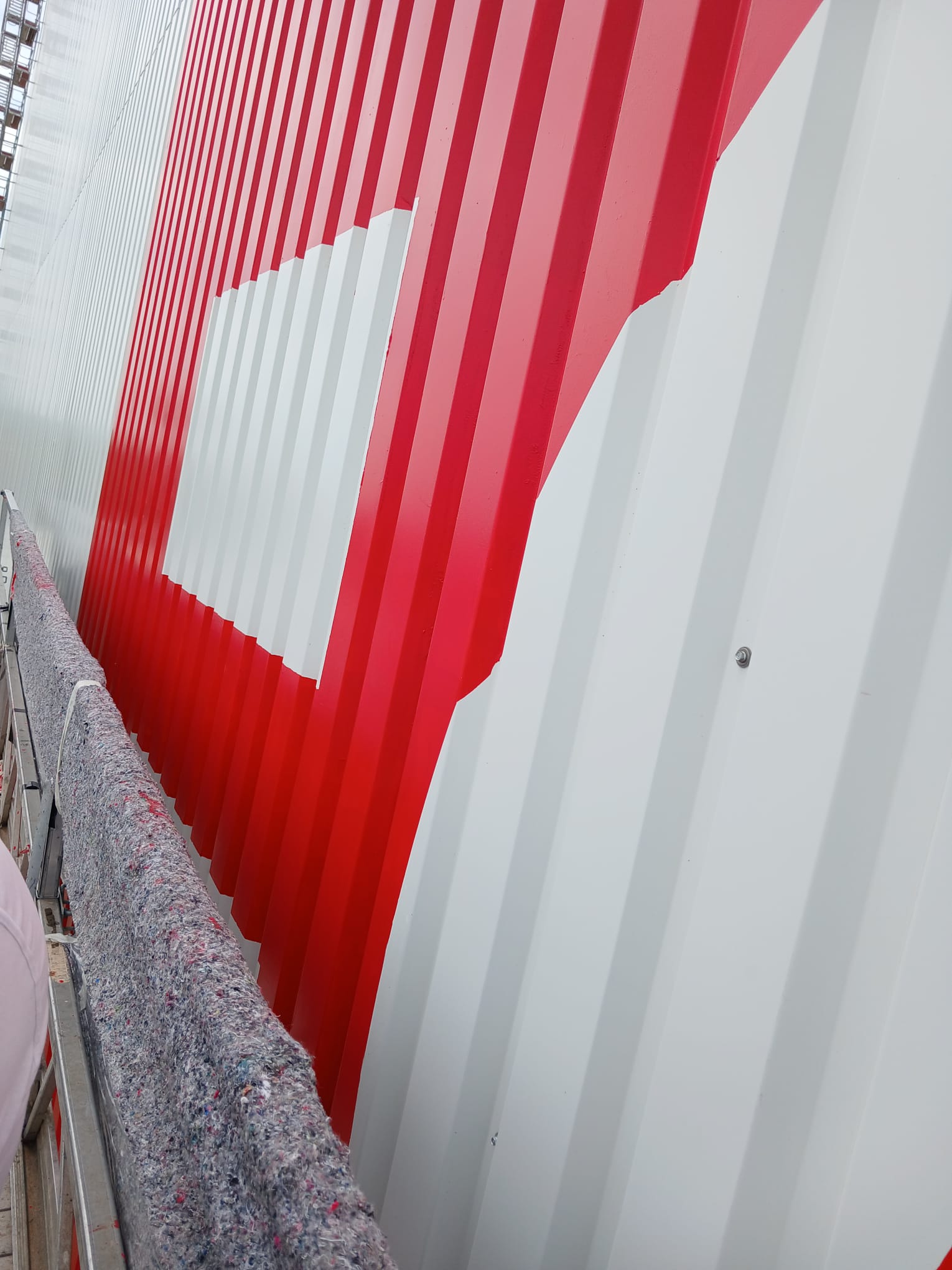 Detailaufnahme der Fassadenbeschriftung in Höffner-Rot RAL 3020 auf der Trapezblech-Fassade