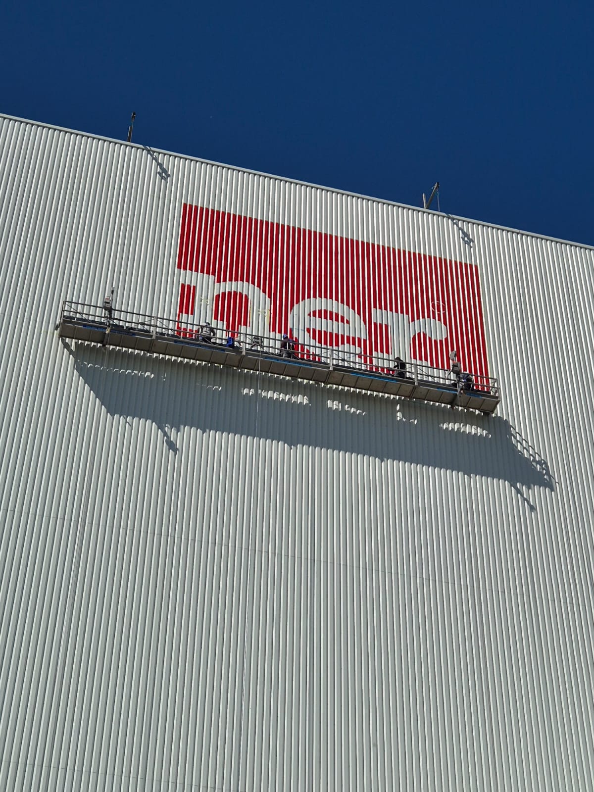 Arbeiten aus der Seilkorbanlage am Höffner-Werbeschriftzug in großer Höhe