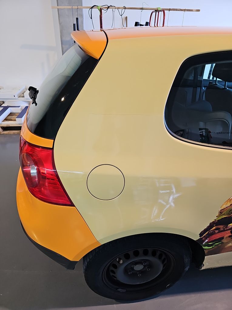 Detail der Folienkante am Tankdeckel: sauberer Übergang zwischen Orange und Creme