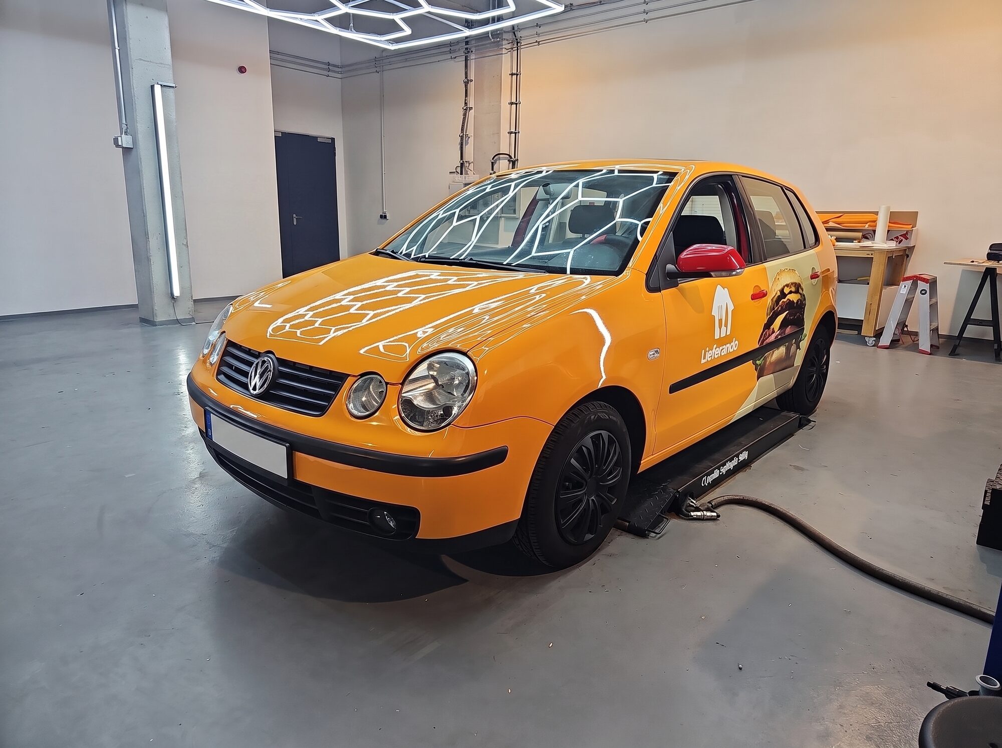 Folierter VW Polo im Lieferando-Design in der Werkstatt von POS Werbung