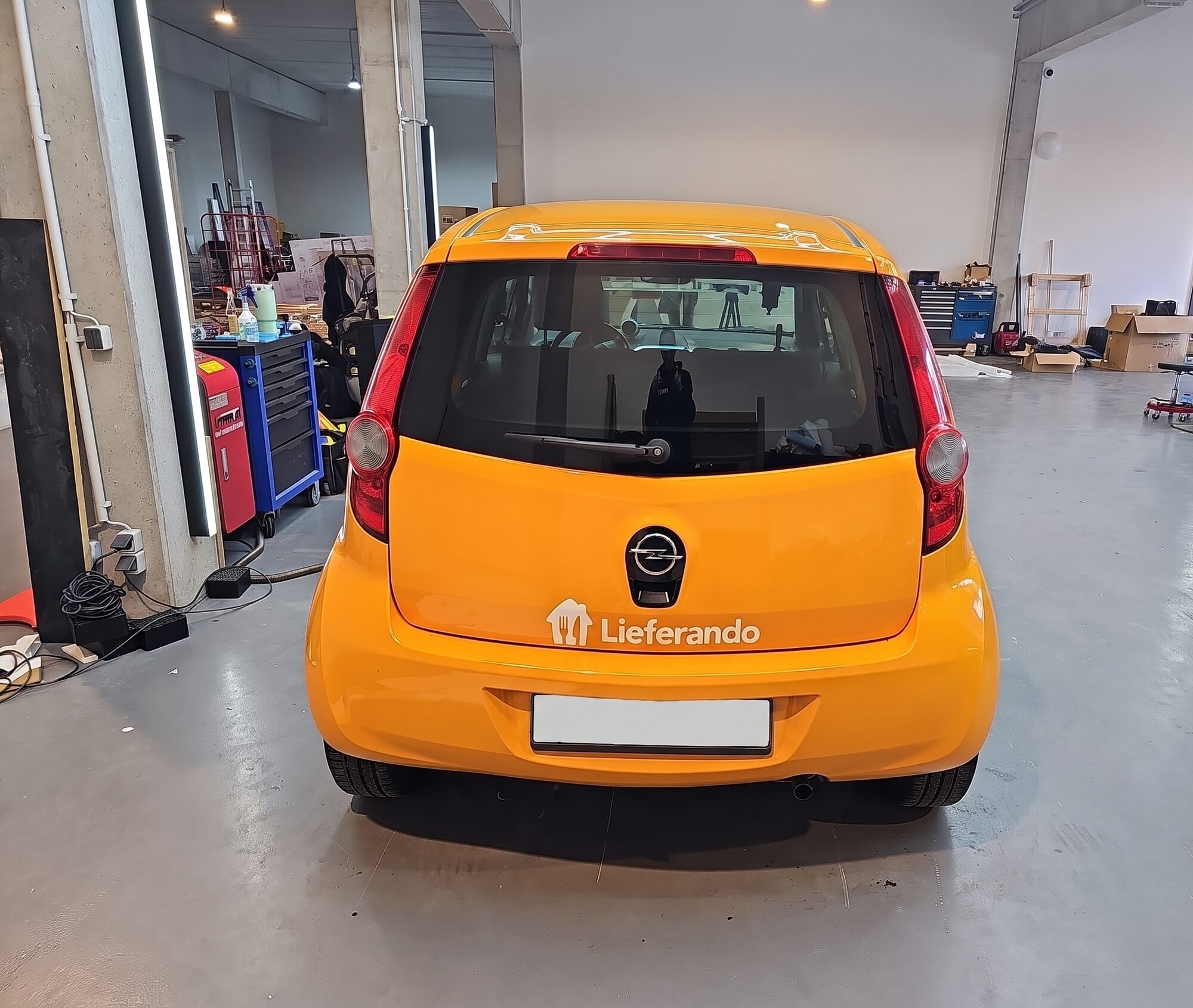 Heckansicht eines folierten Opel mit Lieferando-Schriftzug