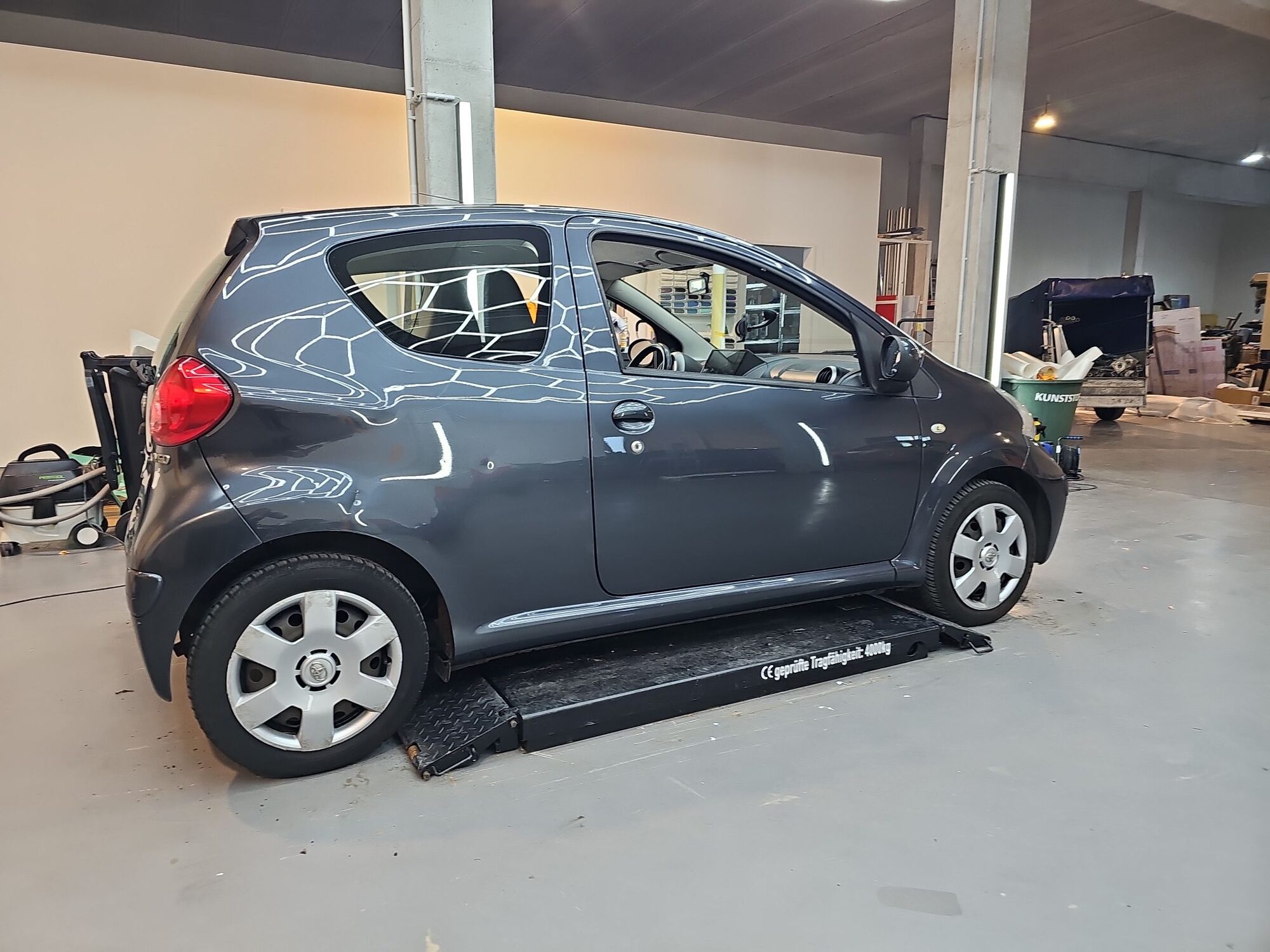 Vorher: Toyota Aygo im grauen Originallack auf der Hebebühne