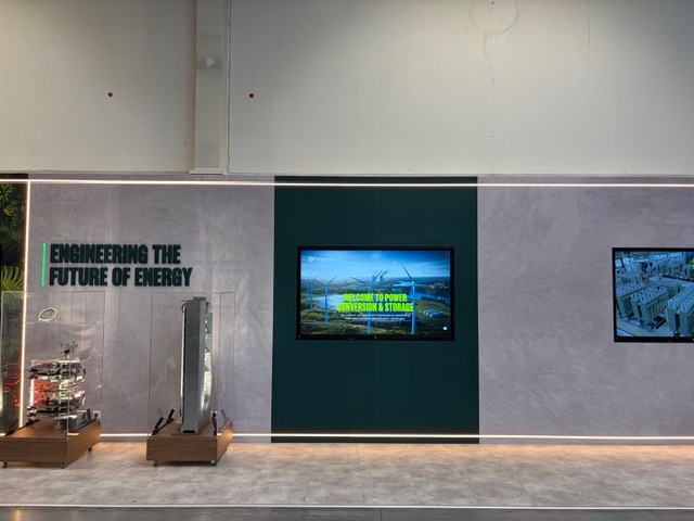 3D-Claim und dunkelgrünes Monitorfeld an der Showwand