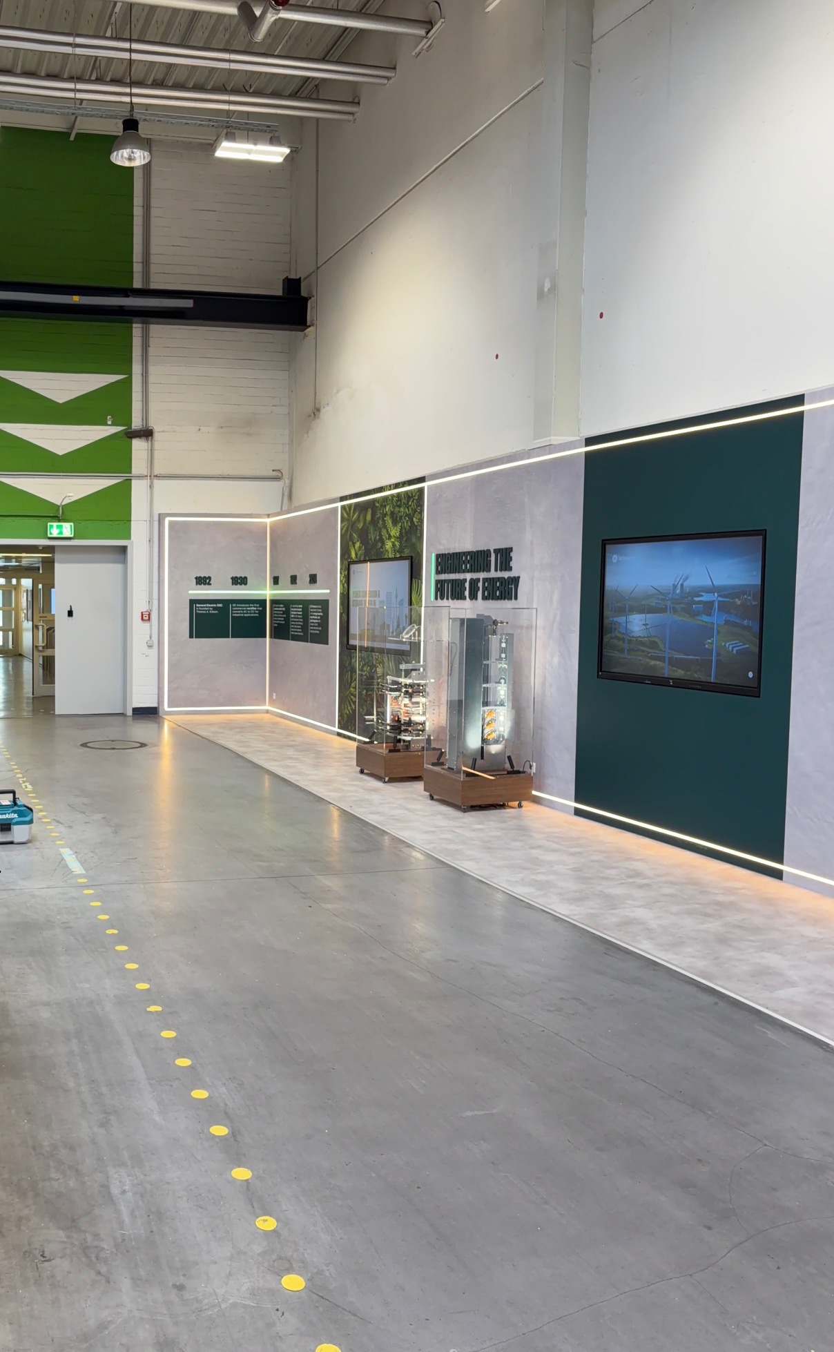 Fertige Showwand im Hallengang mit LED-Linie, Monitoren und Vitrinen