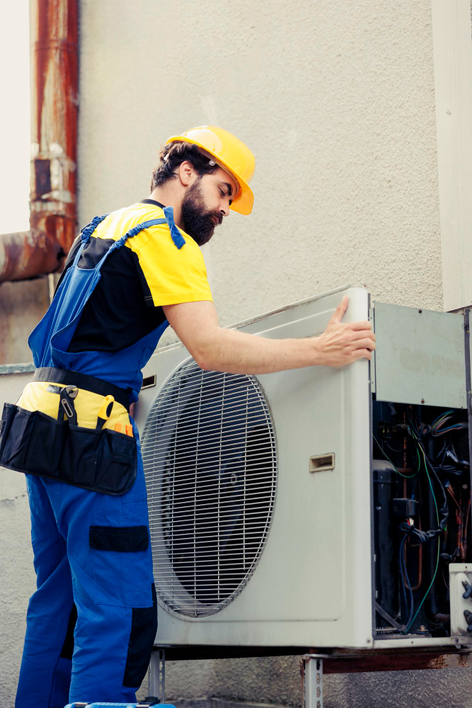 Technician repairing AC system – HVAC Contractor in Wells County, IN