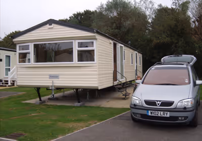 A car parked in front of a mobile home.