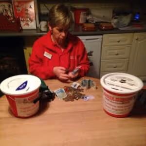 A person sitting at a table with two buckets of food.