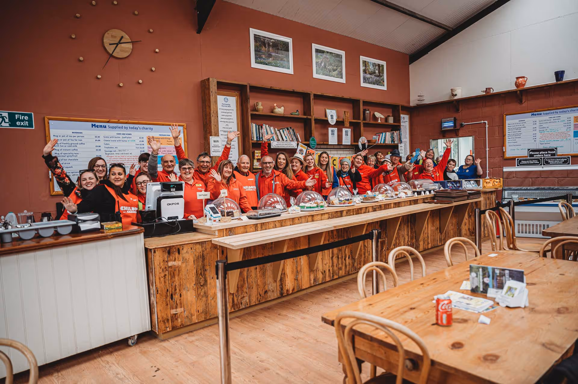 A group of people in red shirts standing behind a counter.