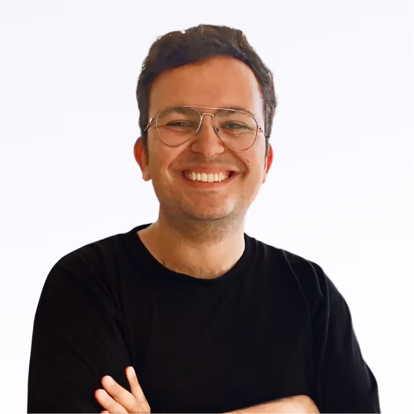 Spikerz Creative Marketing Manager Elior with glasses wearing a black shirt with arms crossed on a white background.