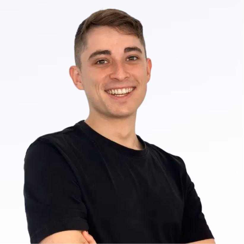 Spikerz Account Executive Noah with short brown hair wearing a black t-shirt, standing with arms crossed against a white background.