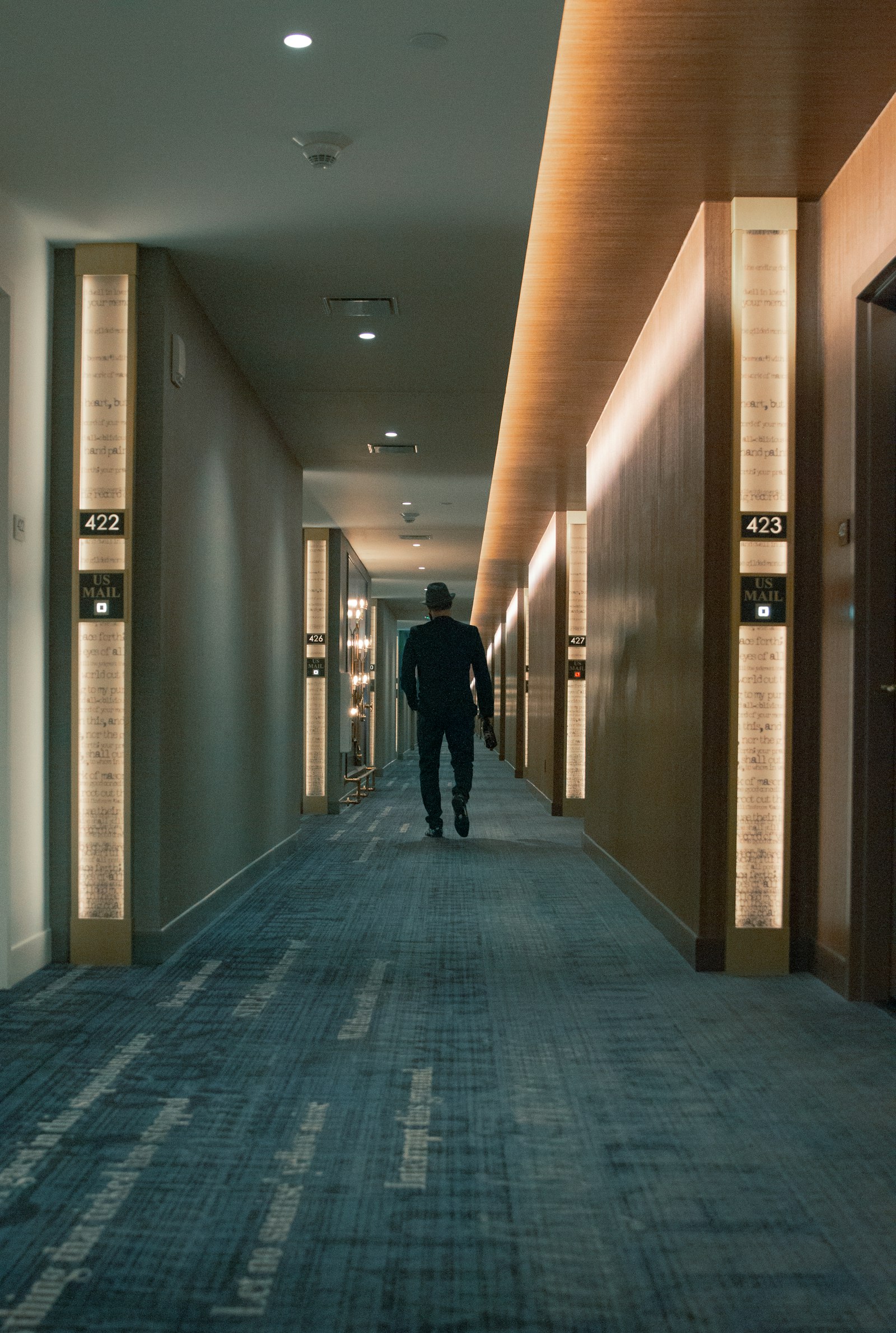 Man walking down a hotel corridor