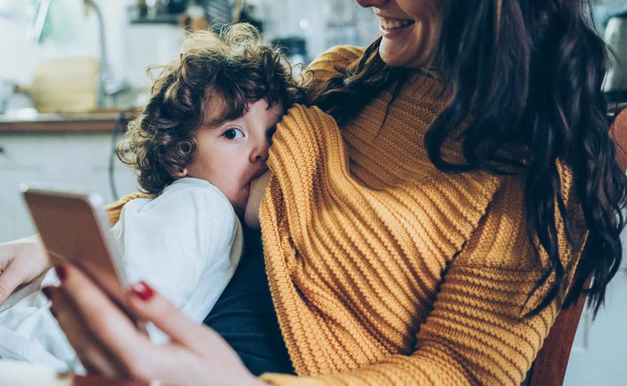 Mamá dándole teta a bebé de 2 años