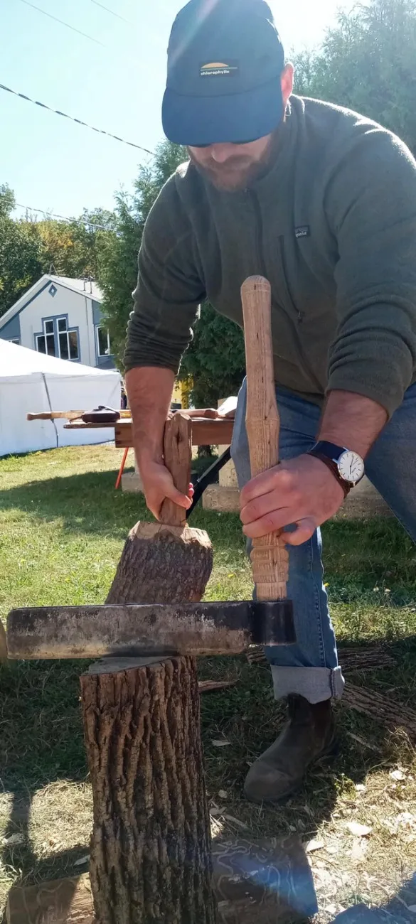 Vue aérienne d’un événement extérieur regroupant de nombreuses tentes blanches, des machineries forestières et acéricoles exposées, ainsi que des visiteurs circulant dans les allées entre les kiosques.