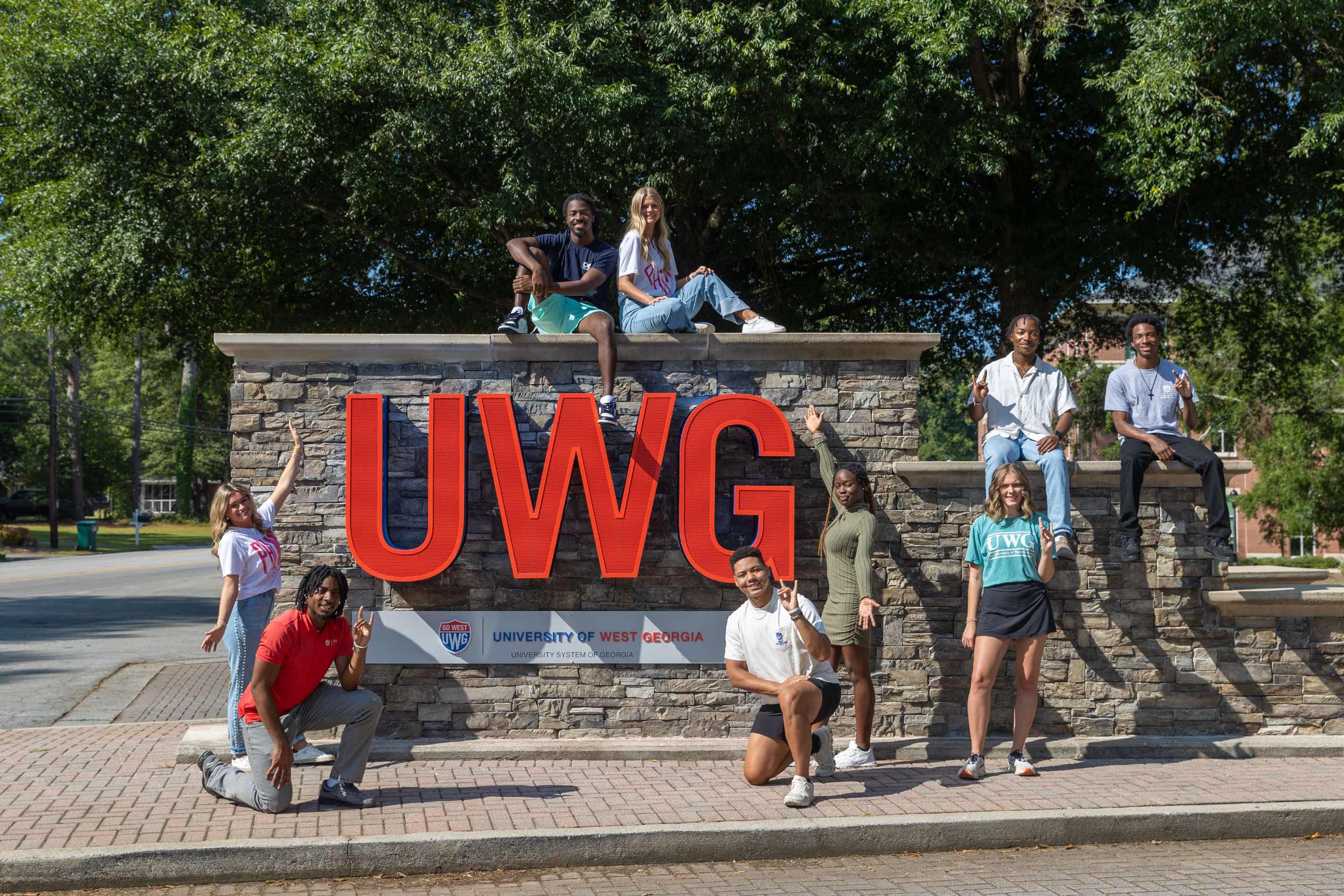 College students pose in front of a UWG sign for University of West Georgia.