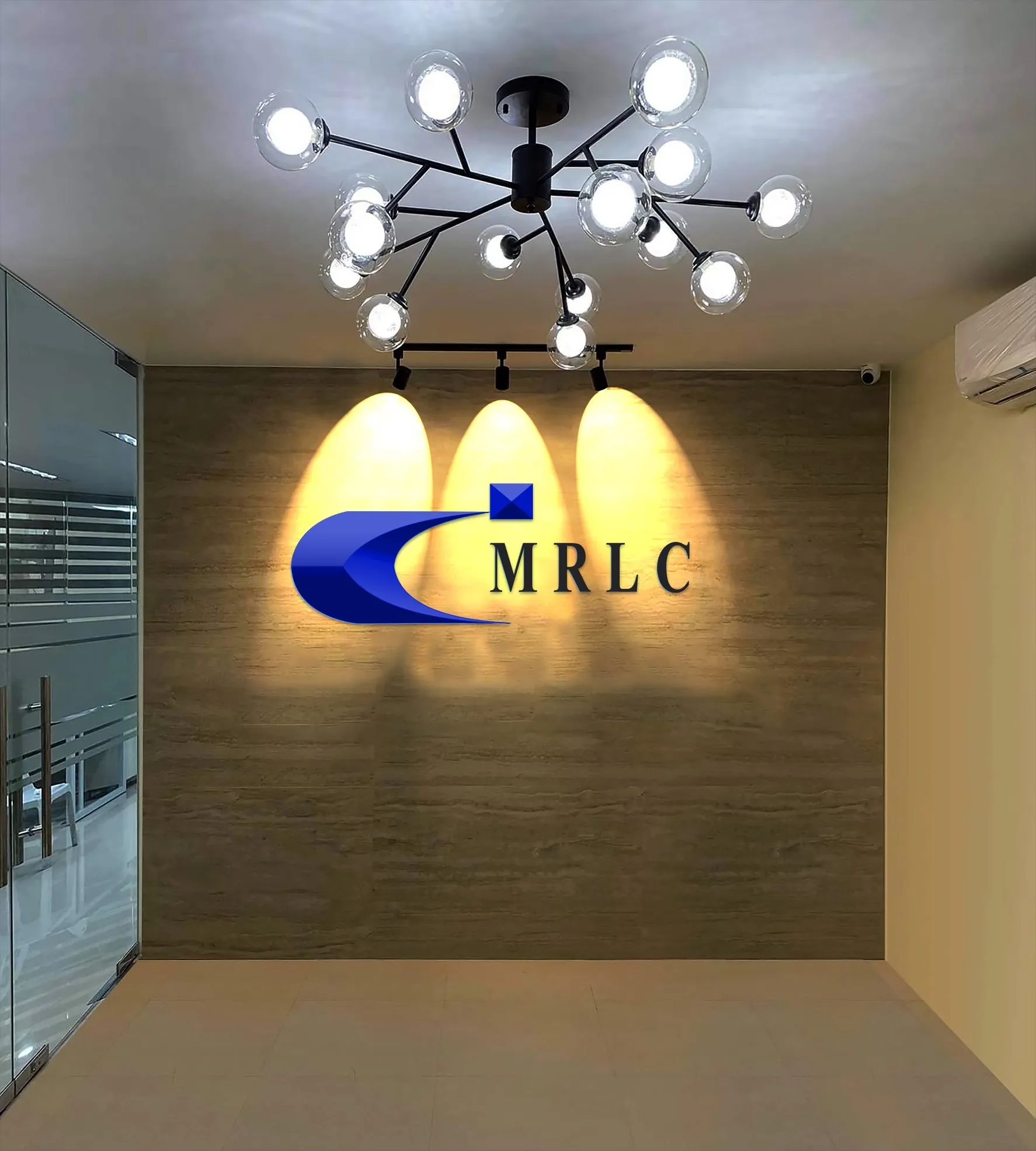 Modern office lobby with a wood-paneled wall, glass door, decorative ceiling light, and MRLC logo.