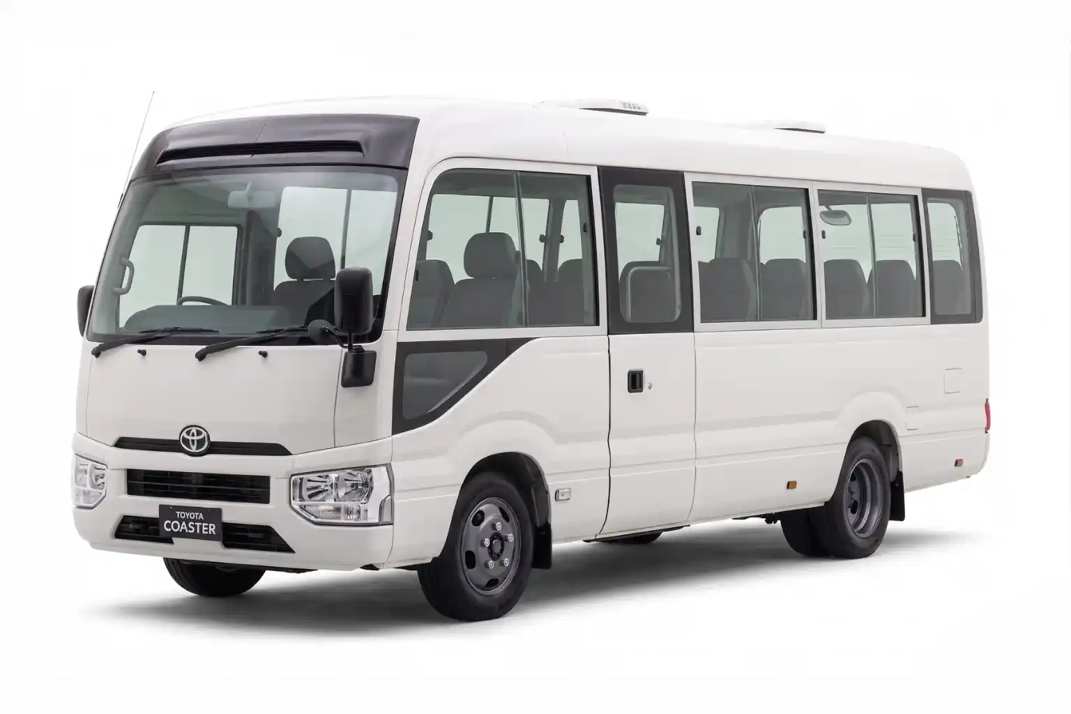 White Toyota Coaster minibus shown from front-side angle on white background.