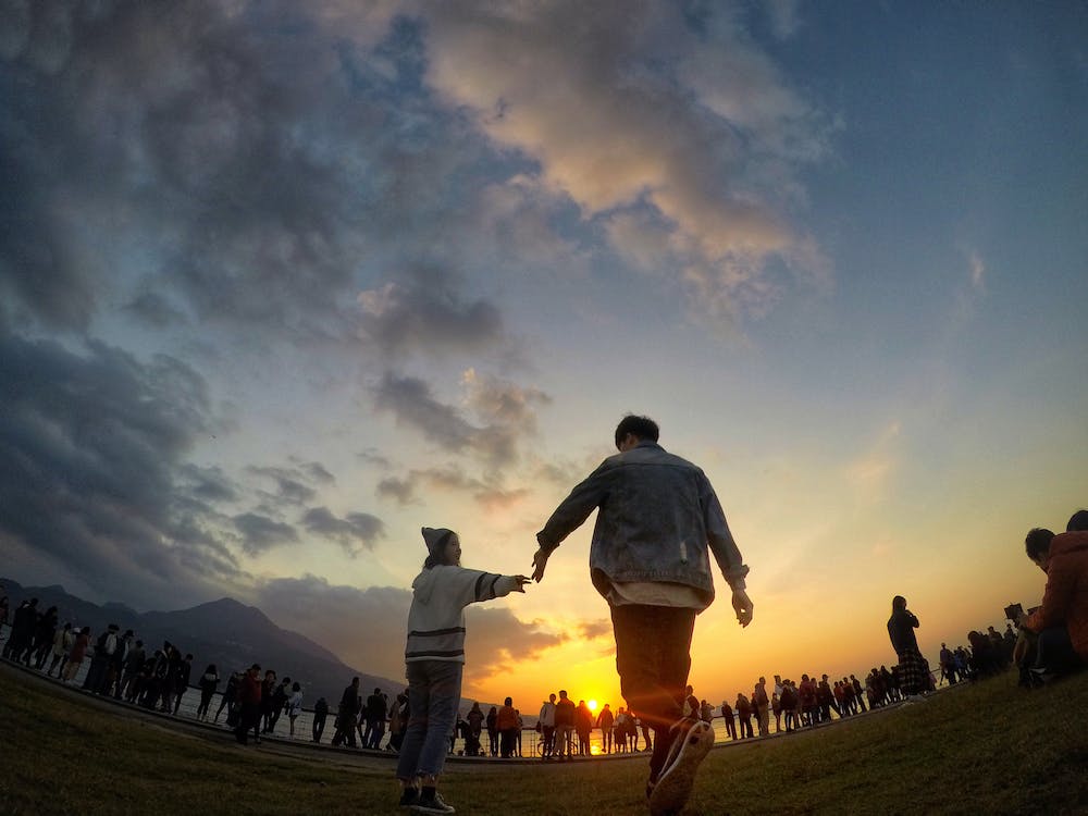 Free Black Haired Man Wearing Blue Denim Jacket and Orange Pants during Sunset Stock Photo