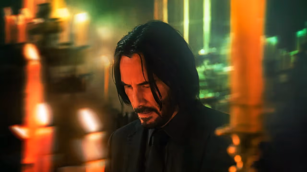John Wick moving through the lights of a city
