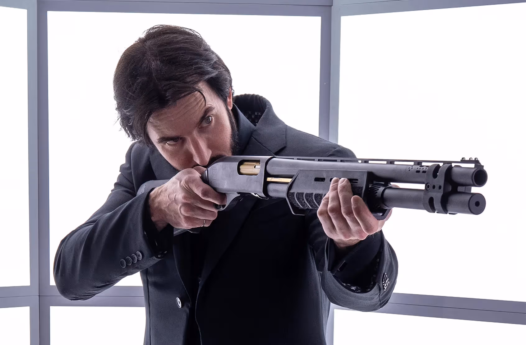 James Hacksmith wearing John Wick's bulletproof jacket pointing a shotgun