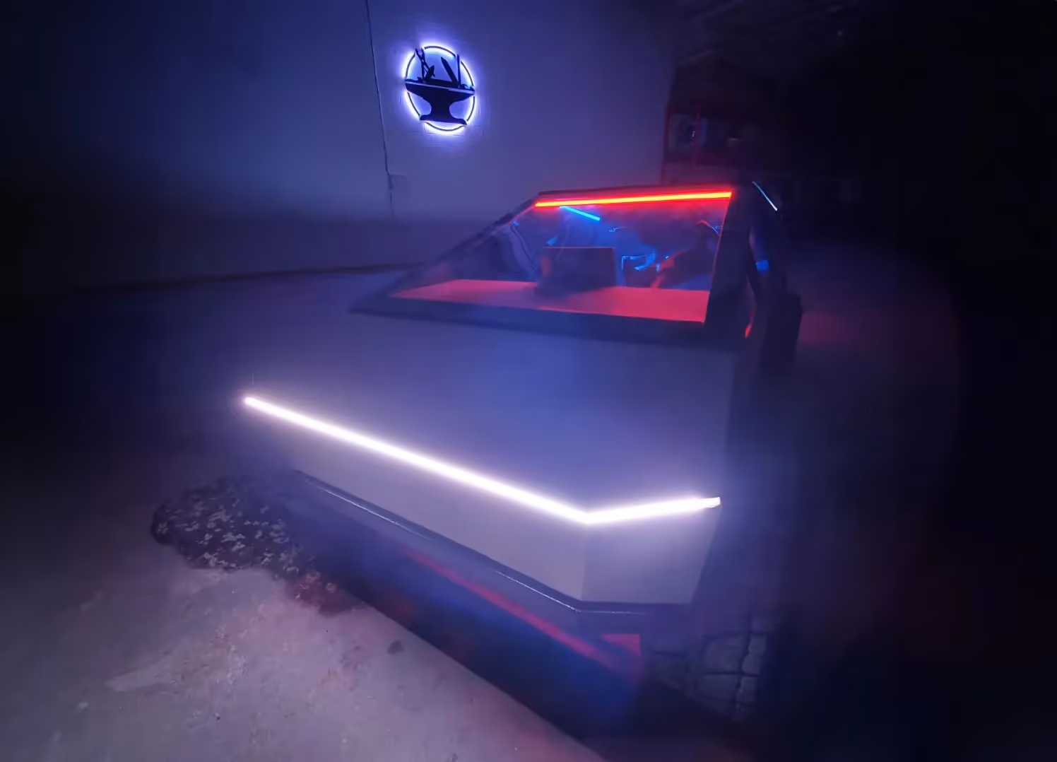 The half scale Cybertruck in the dark inside HERC with the headlight on