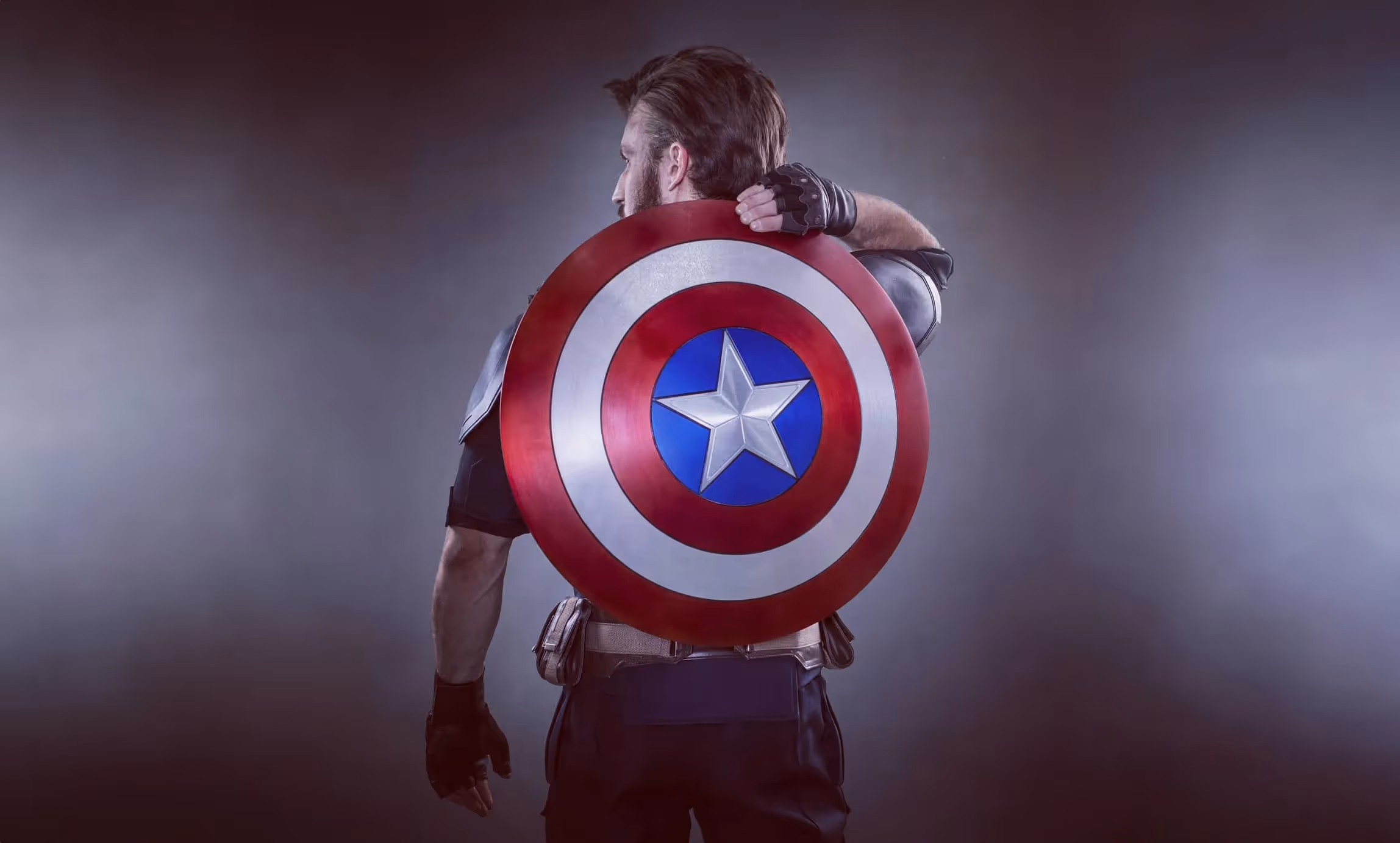 James dressed up as Captain America, reaching to grab the shield from his back