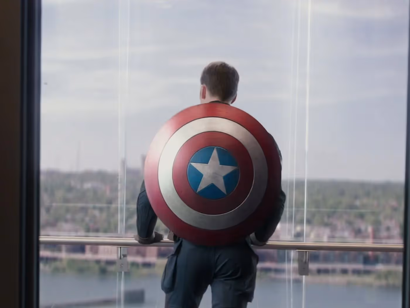 Chris Evans with Captain's America shield from the back, looking at a view