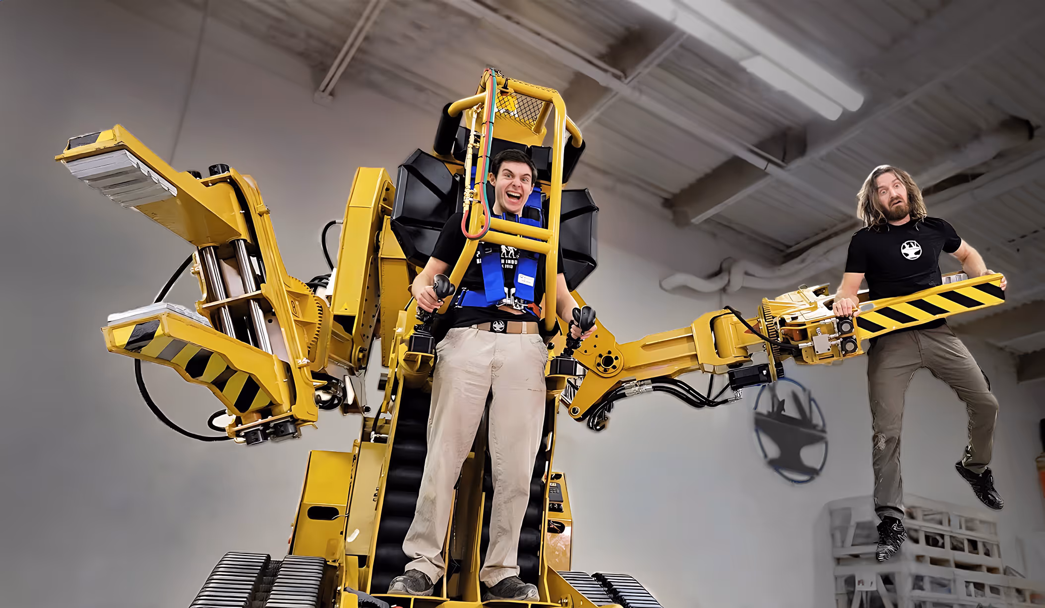 Bogdan driving the Powerloader built by Hacksmith, grabbing James with one arm