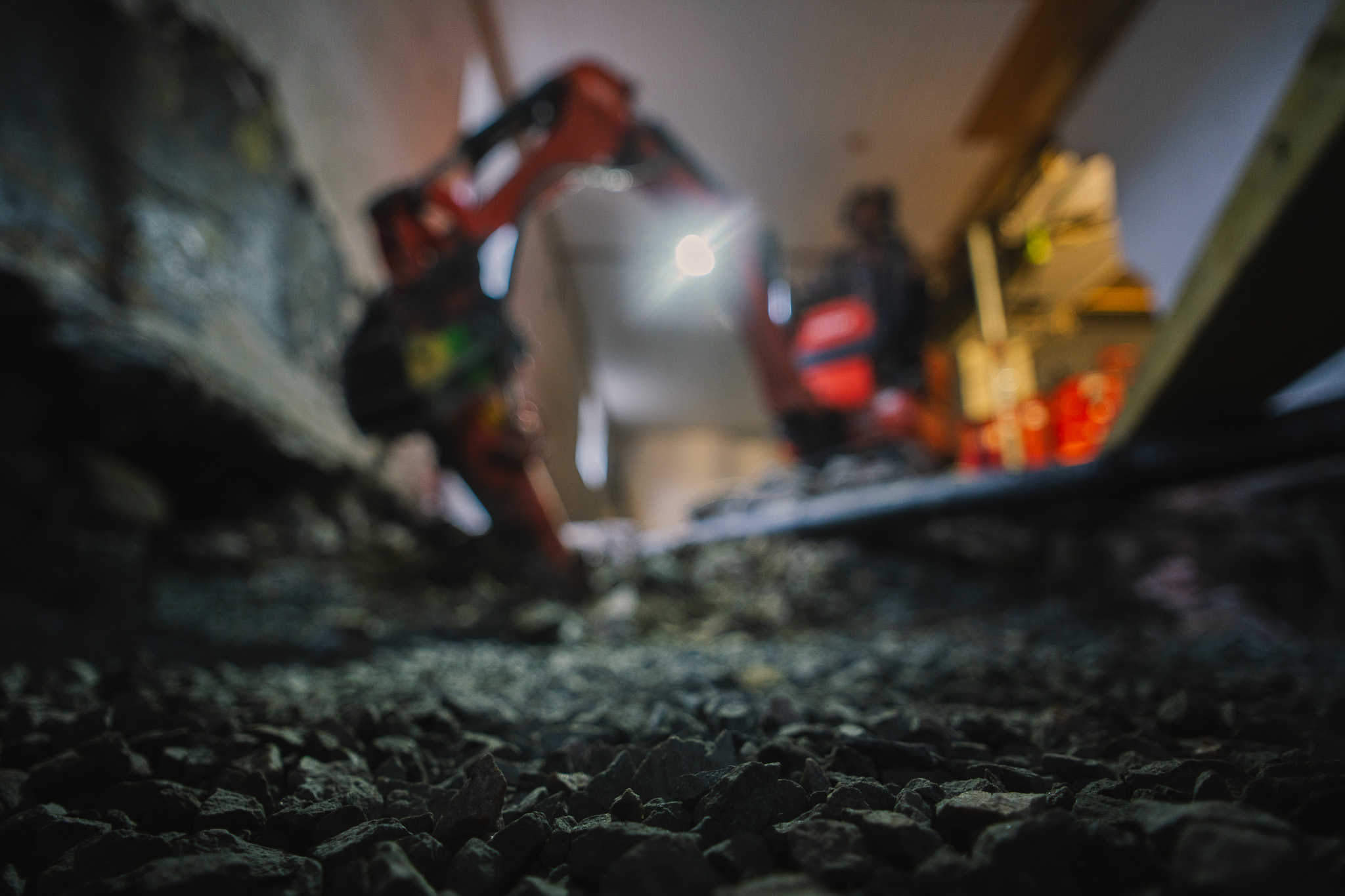 Gravemaskin i bakgrunn, grus i forgrunn.