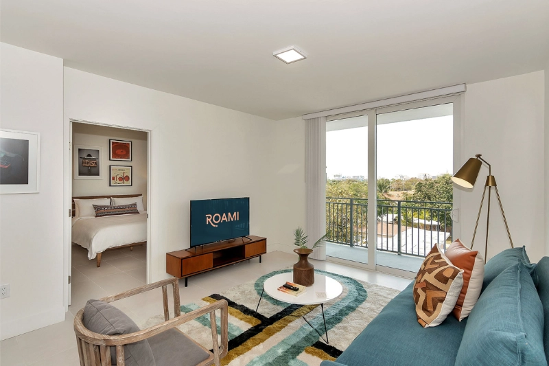 living room with balcony doors and view into the bedroom at grove 27 by roami